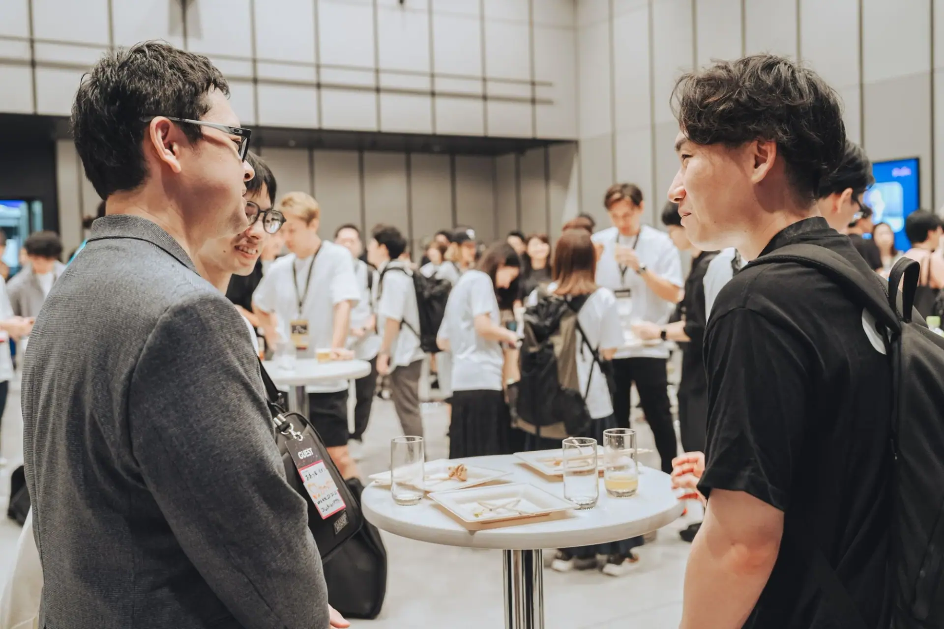 立ち席のテーブルを囲んで、参加者どうしが向かい合って話している会場の様子